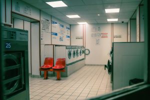 Deretan kursi tunggu di samping mesin pengering outlet laundry koin